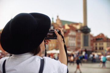 The girl in the black hat shooting in an old european town.