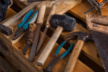 Old carpentry work tools on a brown wooden table background.