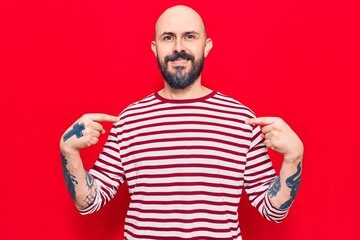 Naklejka premium Young handsome man wearing casual clothes looking confident with smile on face, pointing oneself with fingers proud and happy.