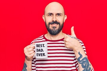 Young handsome man drinking mug of coffe with best dad ever message smiling happy and positive,...