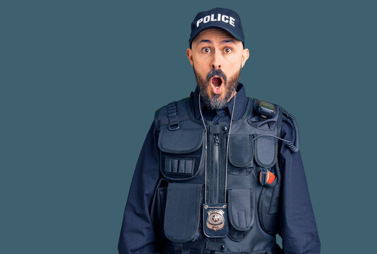 Young handsome man wearing police uniform afraid and shocked with surprise and amazed expression, fear and excited face.