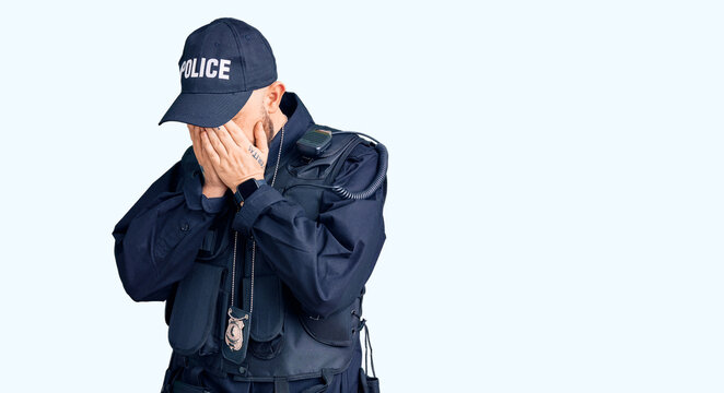 Young handsome man wearing police uniform with sad expression covering face with hands while crying. depression concept.