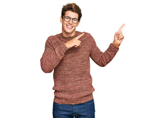 Handsome caucasian man wearing casual sweater and glasses smiling and looking at the camera pointing with two hands and fingers to the side.