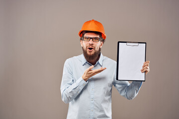 A man in a shirt with an orange hard hat engineer work documents rendering services