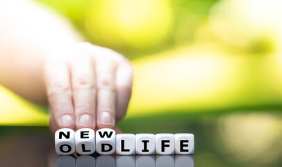 Hand turns a dice and changes the expression "old life" to "new life"..