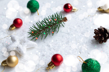 Fototapeta na wymiar Multicolored Christmas balls and a fir sprig with a star on a white background with space for text. Layout of a postcard, poster.