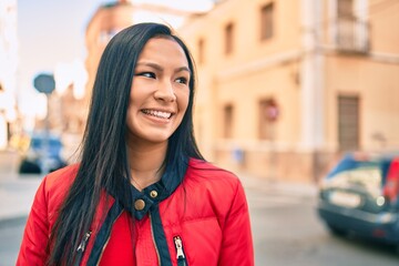 Young latin woman smiling happy walking at the city.