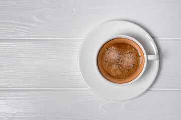 Cup of coffee and saucer on white background. Copy space, top view