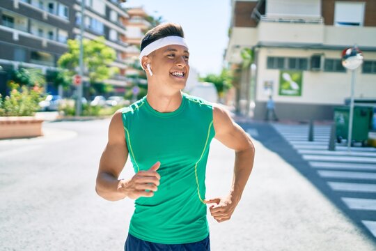 Young hispanic sportsman smiling happy running at street of city
