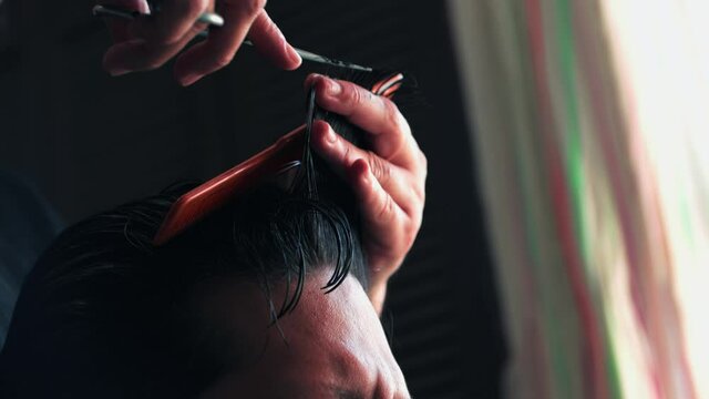 Joven mujer corta cabello a hombre en casa peque&ntilde;o negocio propio emprendedora