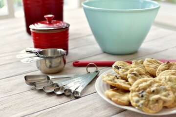 Freshly made homemade chocolate chip cookies warm from oven ready to eat with baking equipment background