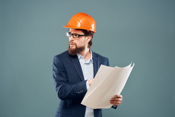 Male engineer with blueprints in the hands of an orange hard hat Industry professional