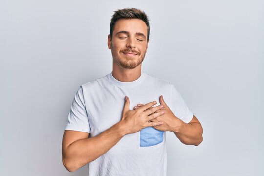 Handsome caucasian man wearing casual clothes smiling with hands on chest, eyes closed with grateful gesture on face. health concept.