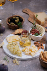 Marble Cheese board with delicous cheeses, nuts, honey and grapes