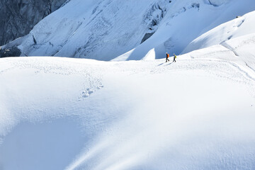 Fototapeta na wymiar Beautiful landscape with trekkers hiking up on White Valley, Mont Blanc massif seen from Aiguille du Midi 3842m, Chamonix, France
