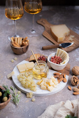 Assorted cheeses on marble plate with figs, nuts, grapes and honey