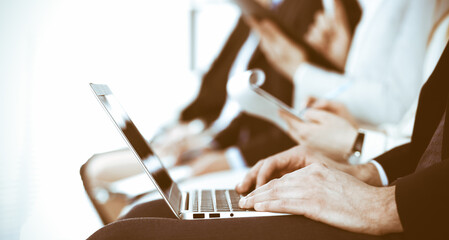 Business people working at meeting or conference, close-up of hands. Group of unknown businessmen and women in modern white office. Teamwork or coaching concept