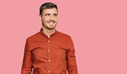 Fototapeta premium Handsome caucasian man wearing casual clothes looking away to side with smile on face, natural expression. laughing confident.