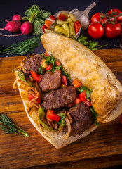 Delicious Turkish Meatballs Sandwich  Kofte Ekmek. Ingredients with bread crumbs  butter  sliced onion  parsley  tomato  pickles and seasoning spices. Hamburger serving on wood table background. 
