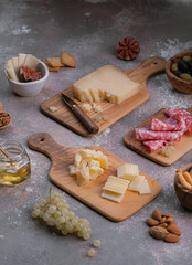 Tiny boards full of cheese, salumi, nuts and grapes
