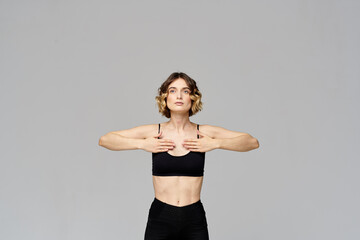 Fototapeta na wymiar Sporty woman in leggings on a gray background is engaged in fitness Copy Space