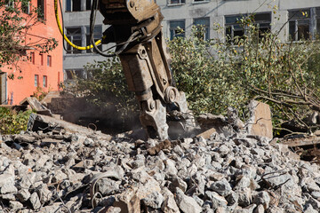 excavator at a construction site demolishes an old building