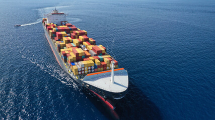 Aerial drone photo of huge container tanker ship carrying truck size colourful containers in deep...
