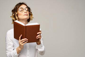Business woman with notepad and glasses on a light background hairstyle success emotions