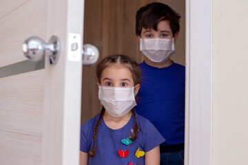 Fototapeta na wymiar A brunette boy and a girl, in blue clothes and white medical masks