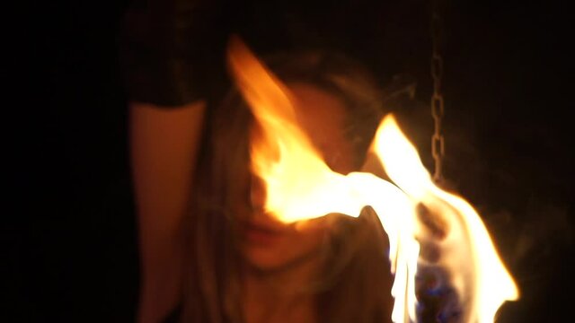 Girl hold the fire in front of her face 2