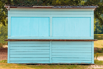 Closed beach bar made of blue painted wood planks and timber, front view looking onto closed doors,...