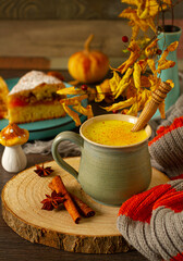 Golden turmeric milk with cinnamon, honey, and ginger in an autumn decor