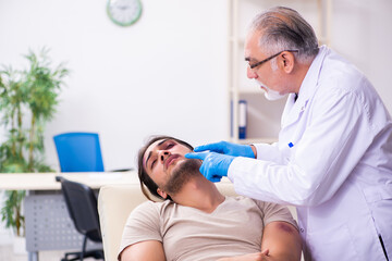 Young face injured man visiting experienced male doctor traumato