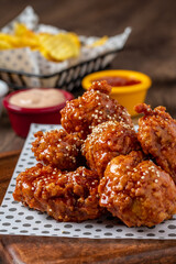 Baked chicken wings with sesame and sauce on wooden background