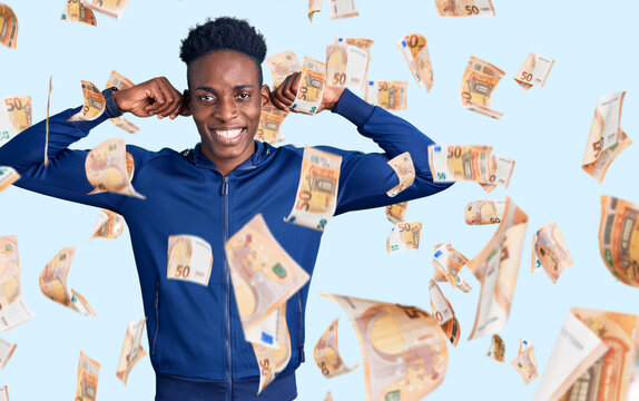 Young african american man wearing sportswear smiling pulling ears with fingers, funny gesture. audition problem
