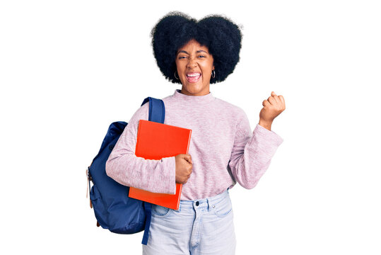 Young african american girl wearing student backpack holding book screaming proud, celebrating victory and success very excited with raised arms