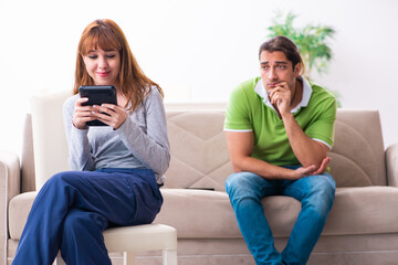 Young couple in gadget dependency concept