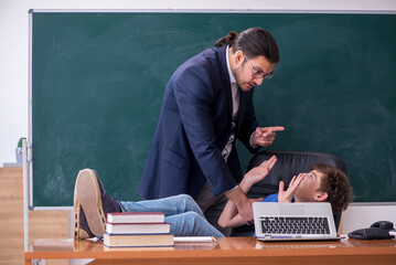 Young male teacher and schoolboy in the classroom