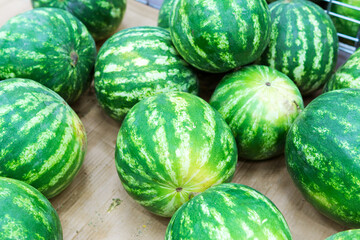 ripe watermelons on the shelves of a hypermarket