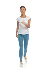 Fototapeta premium Positive casual woman smiling and walking