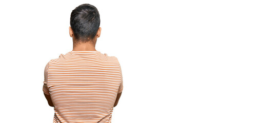Handsome hispanic man wearing casual clothes standing backwards looking away with crossed arms
