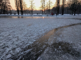 Ice skating in Munich during sunset. Frozen lake during sunset. Ice skating on the Kleinhesseloher lake in Munich.