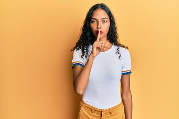 Obraz premium Young african american girl wearing casual clothes asking to be quiet with finger on lips. silence and secret concept.