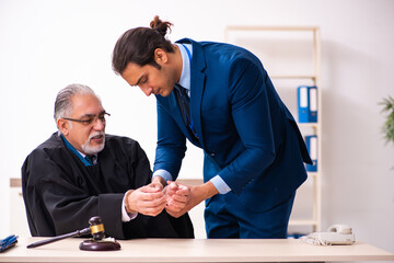 Police inspector arresting old judge in court