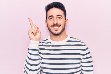 Fototapeta premium Young hispanic man wearing casual clothes smiling happy pointing with hand and finger to the side