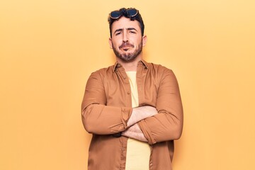 Young hispanic man wearing casual clothes skeptic and nervous, disapproving expression on face with crossed arms. negative person.