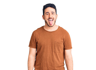 Young hispanic man wearing casual clothes sticking tongue out happy with funny expression. emotion concept.