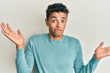 Young handsome african american man wearing casual clothes clueless and confused with open arms, no...