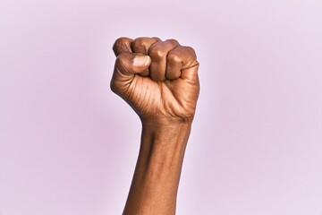Arm and hand of black middle age woman over pink isolated background doing protest and revolution...