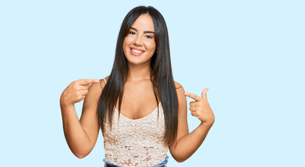 Obraz na płótnie Canvas Young beautiful hispanic girl wearing casual clothes looking confident with smile on face, pointing oneself with fingers proud and happy.
